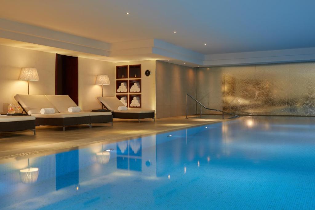 una piscina en una habitación de hotel con sofá en Majestic Hotel Spa - Champs Elysées, en París