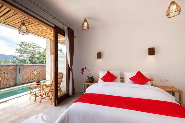 塞隆貝拉納克的住宿－Surya Lombok Accommodation，一间卧室配有一张床,享有游泳池的景色