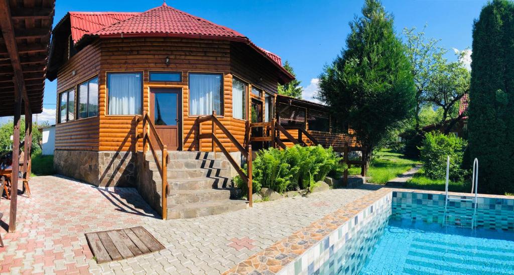 a house with a swimming pool next to a house at Pensiunea Ioana in Borşa