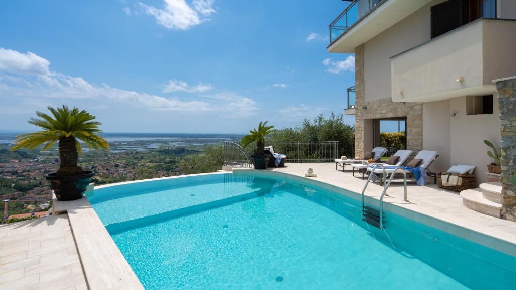 a swimming pool with a view of a house at Villa Dolphin 10, Emma Villas in Massarosa
