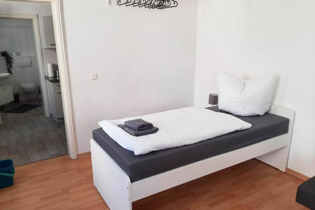 a bed in a room with a white wall at Cozy 1 room apartment in Magdeburg in Magdeburg