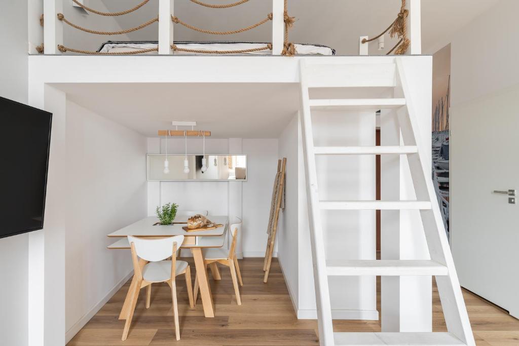 Cama elevada en una habitación pequeña con mesa y sillas en all for Sophie apartments - bezpłatny parking en Gdansk