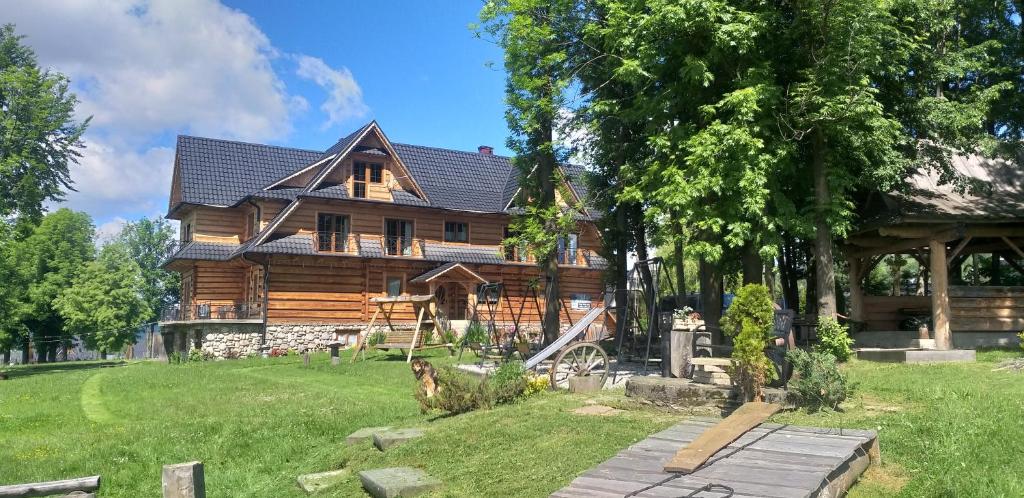 a log cabin with a yard in front of it at Domek, Apartamenty i pokoje Willa Elita in Kościelisko