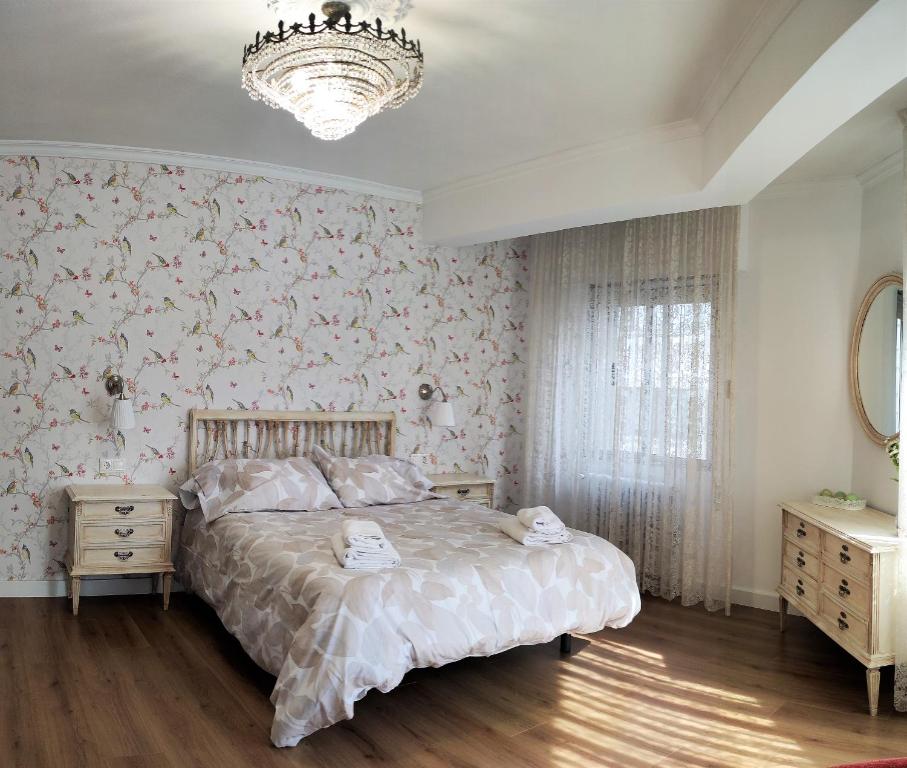 a bedroom with a bed and a chandelier at CARMELA in Santiago de Compostela