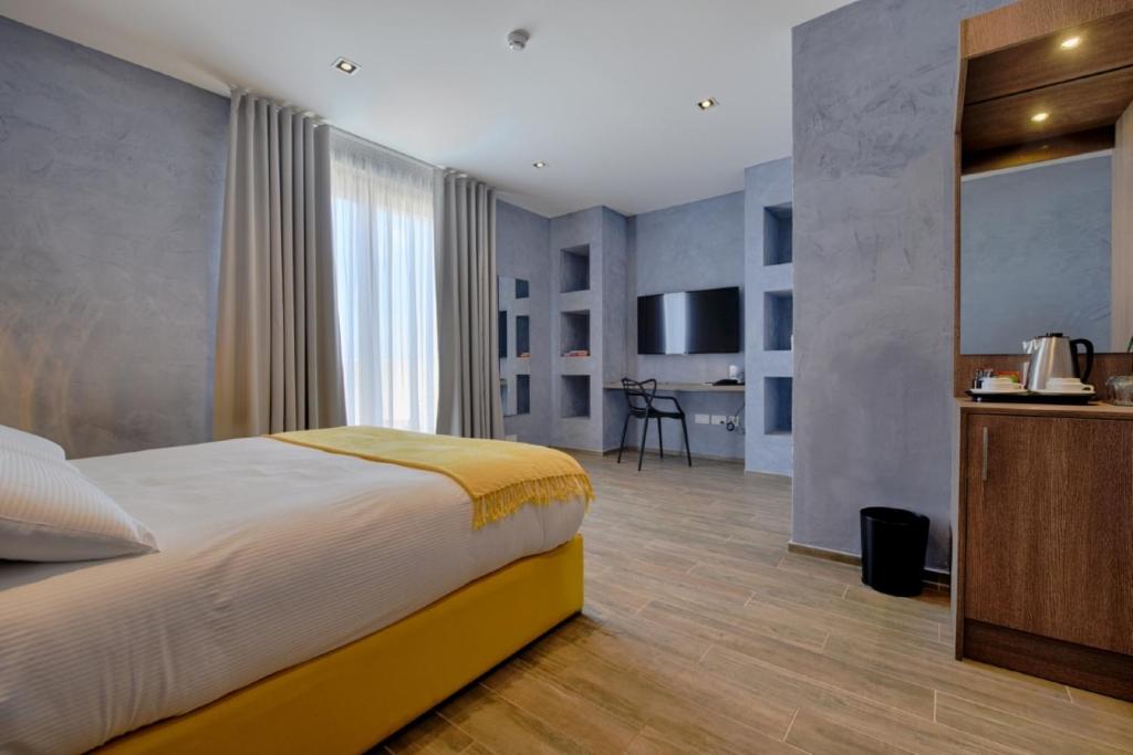 a hotel room with a bed and a kitchen at Quaint Boutique Hotel Xewkija in Xewkija