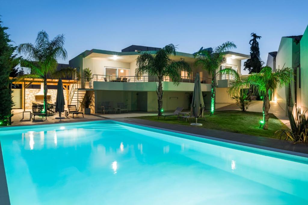 a large swimming pool in front of a house at Villa ARONIOS in Arónion