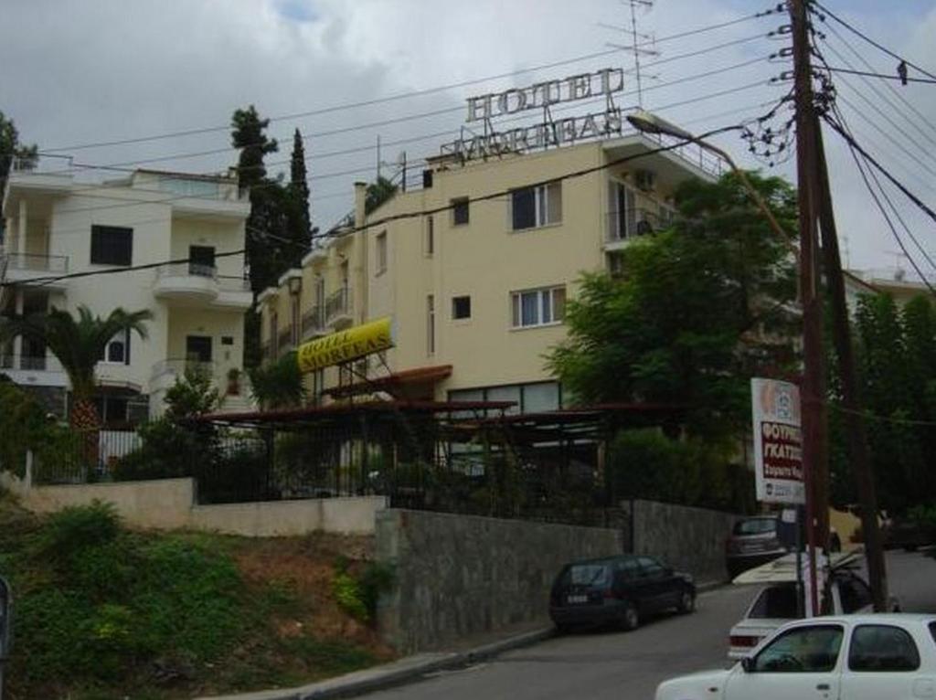 Morfeas Hotel في خالكيذا: مبنى على شارع فيه سيارات تقف امامه