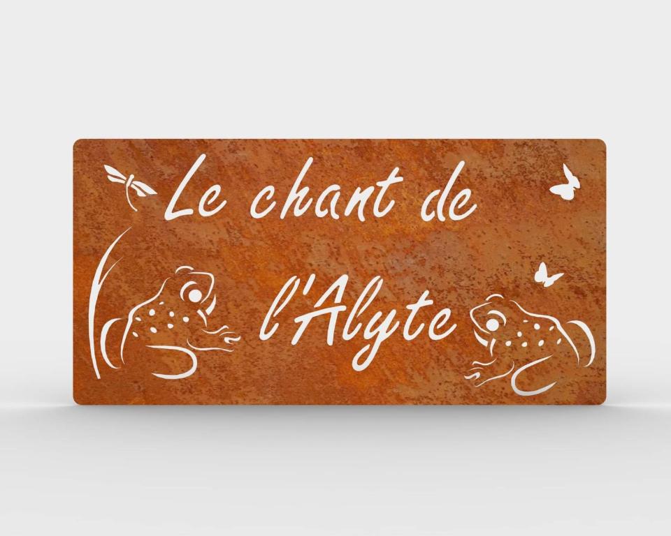 um sinal com um desenho de um sapo e borboletas em Le Chant de l'Alyte em Lens-Lestang