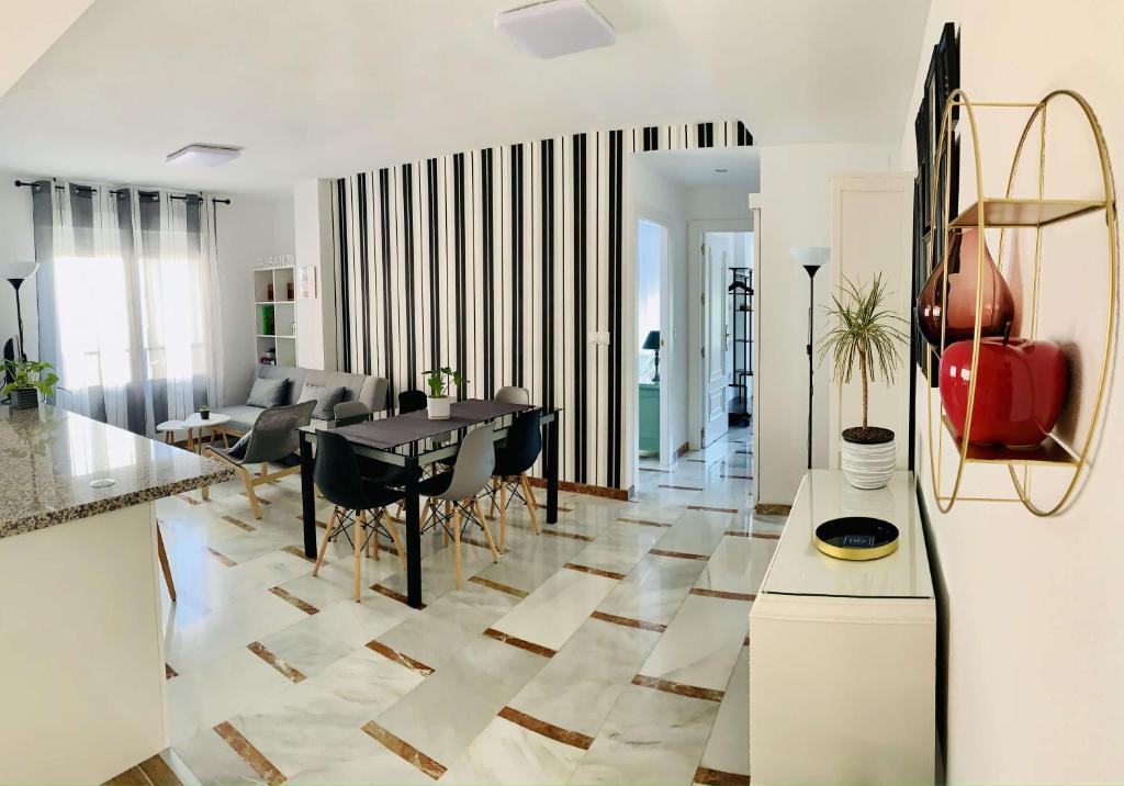 uma cozinha e sala de estar com mesa e cadeiras em FAISÁN 20 Apartamento em Granada
