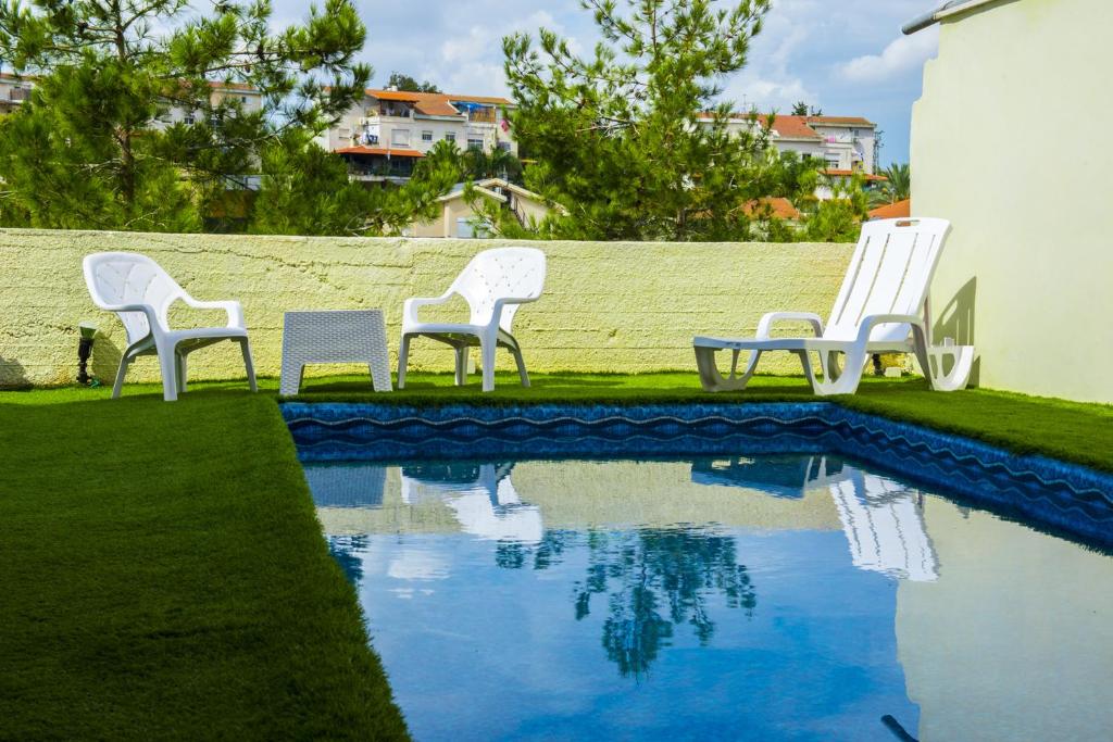 a group of chairs sitting around a swimming pool at Yaakov's Apartment in Migdal Ha‘Emeq
