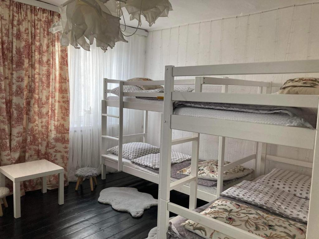 a room with three bunk beds and a table at Warszawska Apartament Rajgród in Rajgród