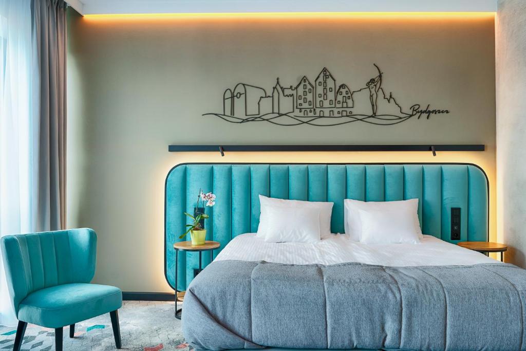sypialnia z niebieskim łóżkiem i niebieskim krzesłem w obiekcie Focus Hotel Premium Bydgoszcz w Bydgoszczy