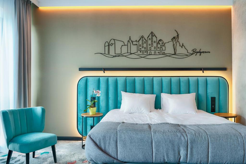 ein Schlafzimmer mit einem blauen Bett und einem blauen Stuhl in der Unterkunft Focus Hotel Premium Bydgoszcz in Bydgoszcz