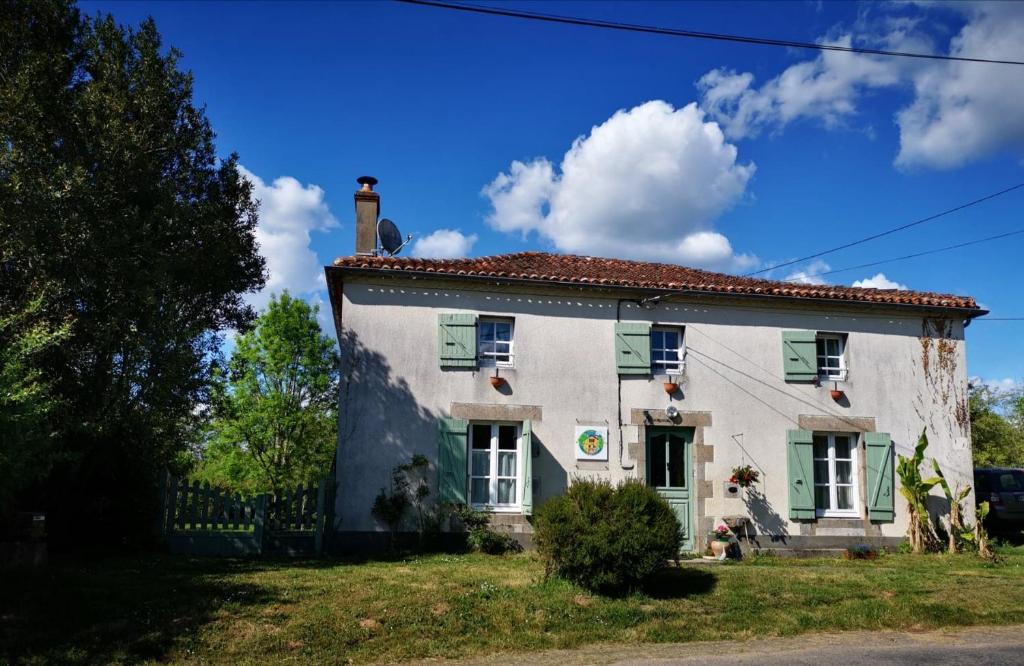 a large white house with green shutters on it at chambres d hotes L'agapé in Saint-Martial-sur-Isop