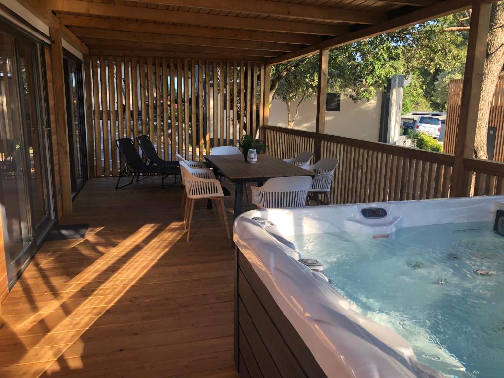 塞尔瑟Luxury Mobile Houses Adria的露台上的热水浴缸，配有桌椅