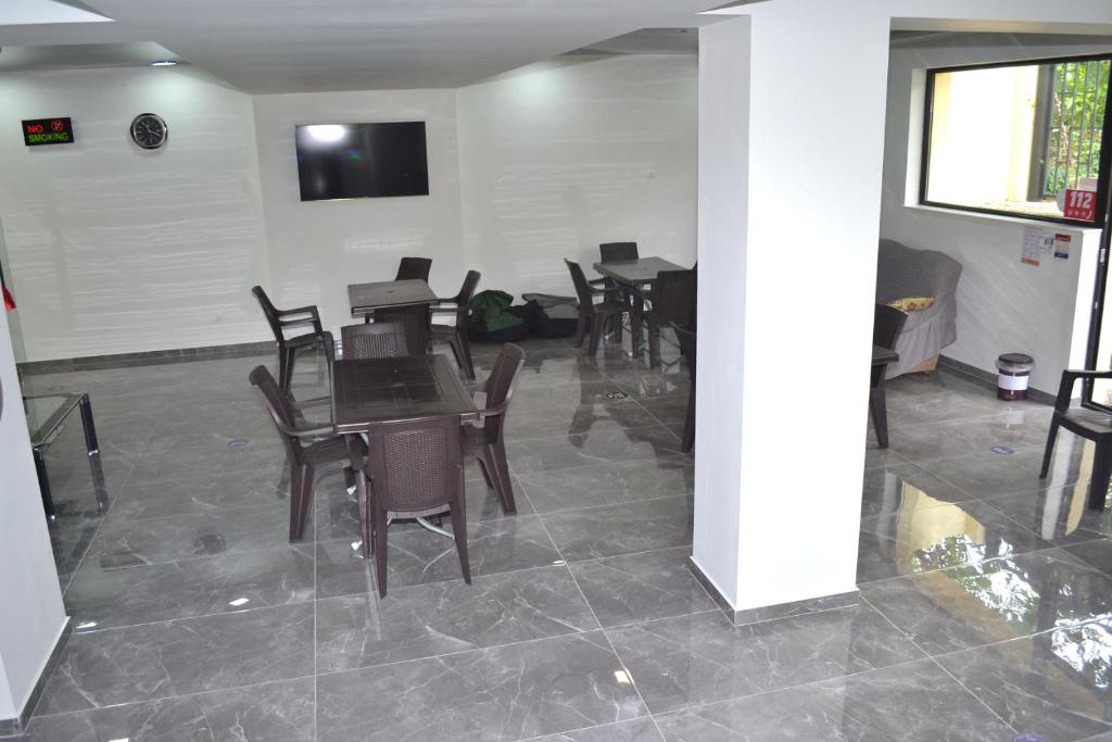a dining room with tables and chairs and a tv at Gurya in K'obulet'i