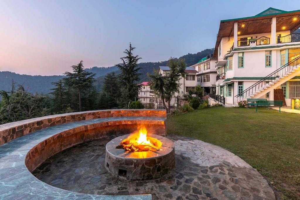 a fire pit in a yard next to a building at StayVista at Vue By The Valley in Chail