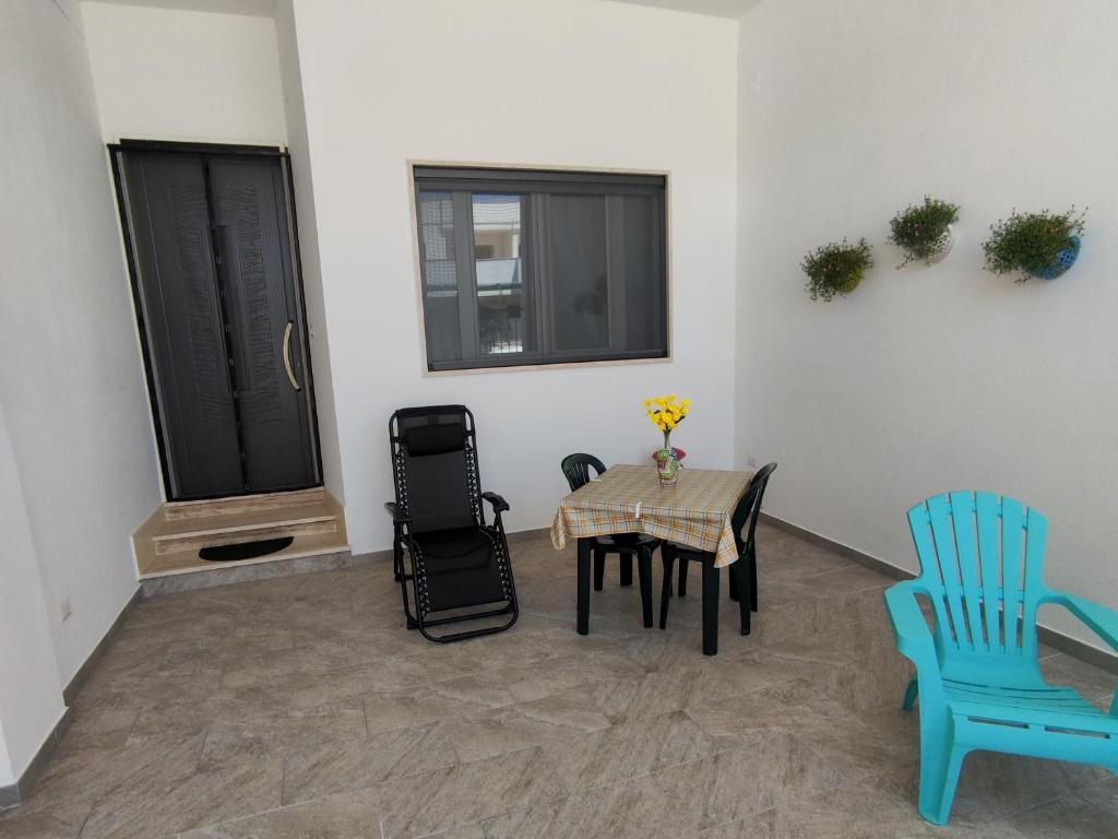 a room with a table and two chairs and a window at Villetta Alka, INTERA casa indipendente in Torre dell'Orso