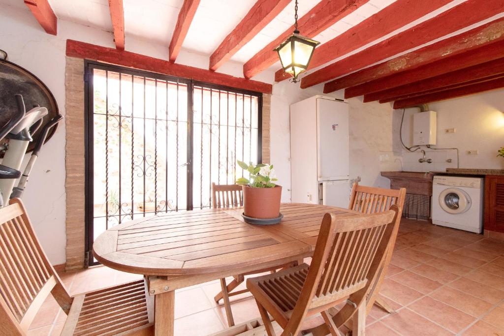 Cuart de les Valls的住宿－Global Properties, Bonita casa rural en Quart de les Valls，一间带木桌和椅子的用餐室