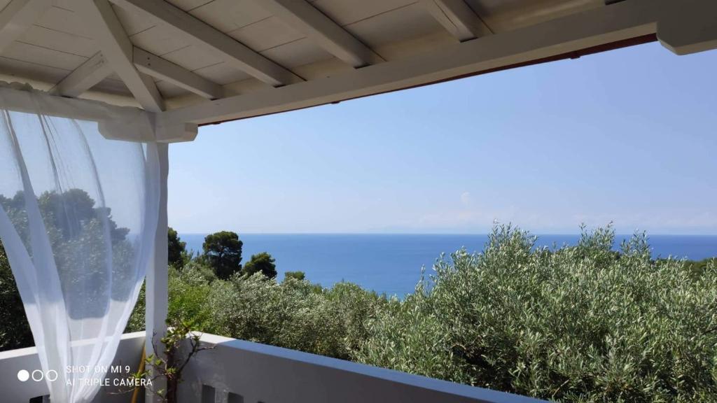 vistas al océano desde el balcón de una casa en Elia house 1 astoning sea view among the olive trees, en Patitiri