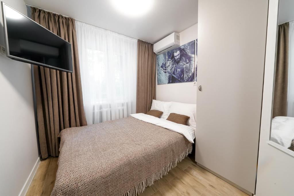 a bedroom with a bed and a flat screen tv at Апартаменти MYFREEDOM поруч інститут Шалімова in Kyiv