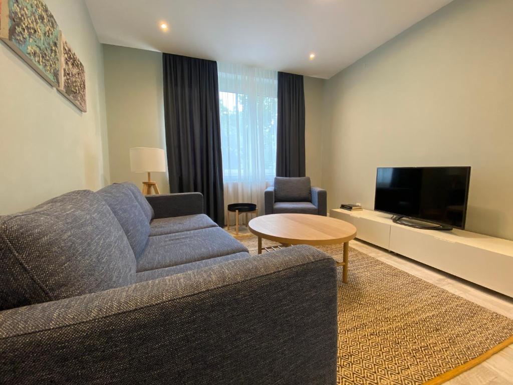 a living room with a couch and a tv at Apartman Teatar in Sombor