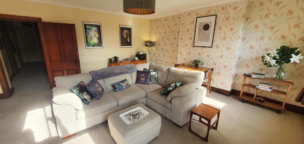 ein Wohnzimmer mit einem Sofa und einem Tisch in der Unterkunft The Apartment at Pen Y Coed Hall in Dolgellau