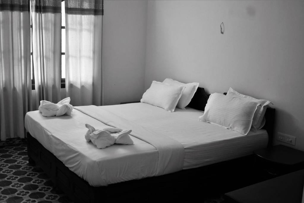 łóżko z dwoma pluszakami siedzącymi na nim w obiekcie 3 Hills Hostel w mieście Wayanad