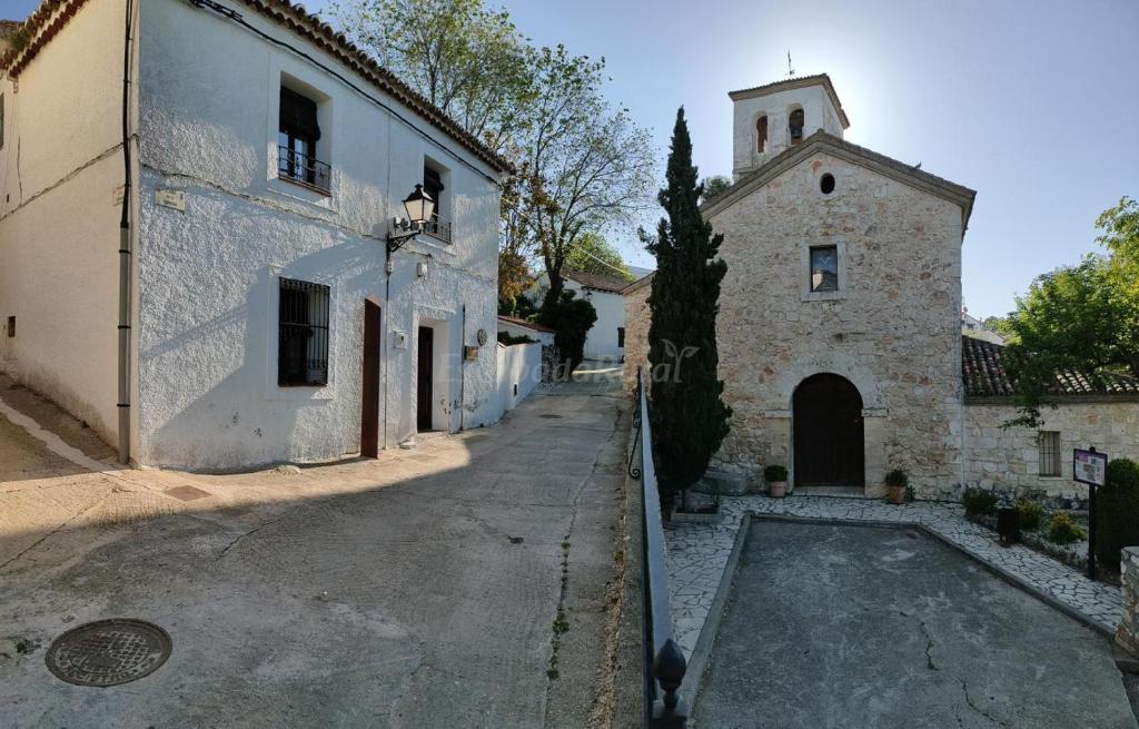 an empty street with a building and a church at Casa del Maestro in Olmeda de las Fuentes
