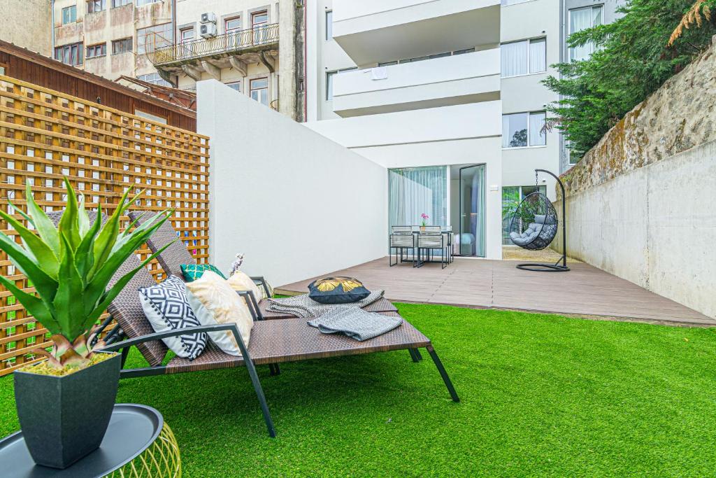 um jardim com um banco e uma mesa na relva em Luxury in the Art District by Innkeeper no Porto