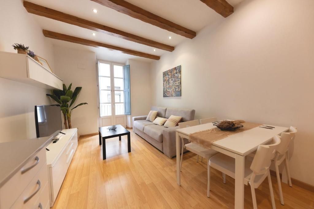 cocina y sala de estar con mesa y sofá en Bravissimo Plaça dels Raïms, en Girona