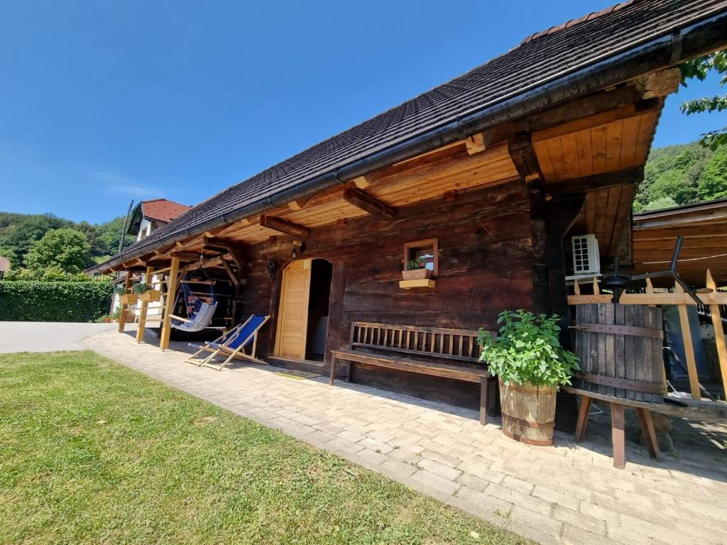 een houten huis met een bank ervoor bij Počitniška hišica Žagar in Podčetrtek