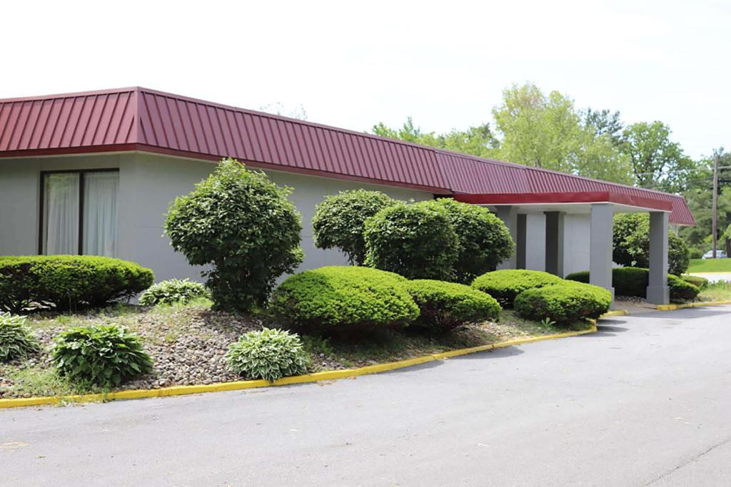 a building with a bunch of bushes in front of it at Days Inn by Wyndham Pottstown in Pottstown