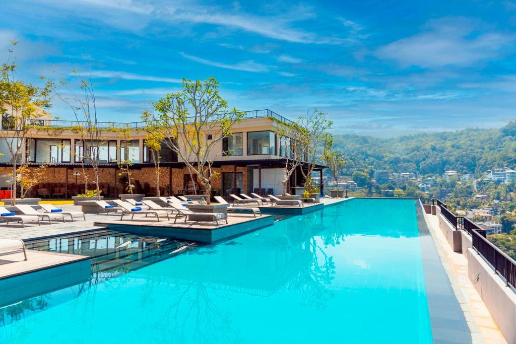 una piscina con sillas y un edificio en Thilanka Hotel, en Kandy