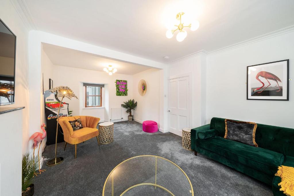 a living room with a green couch and a table at The Palm at the Ferry in Broughty Ferry