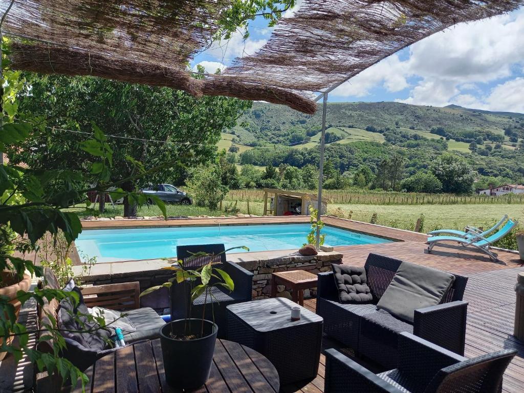a patio with a pool and chairs and a table at Suite chez l'habitant in Itxassou