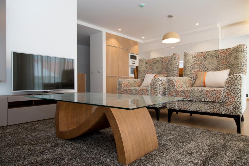 a living room with a glass table and a couch at Apartamentos Turisticos da Nazare in Nazaré