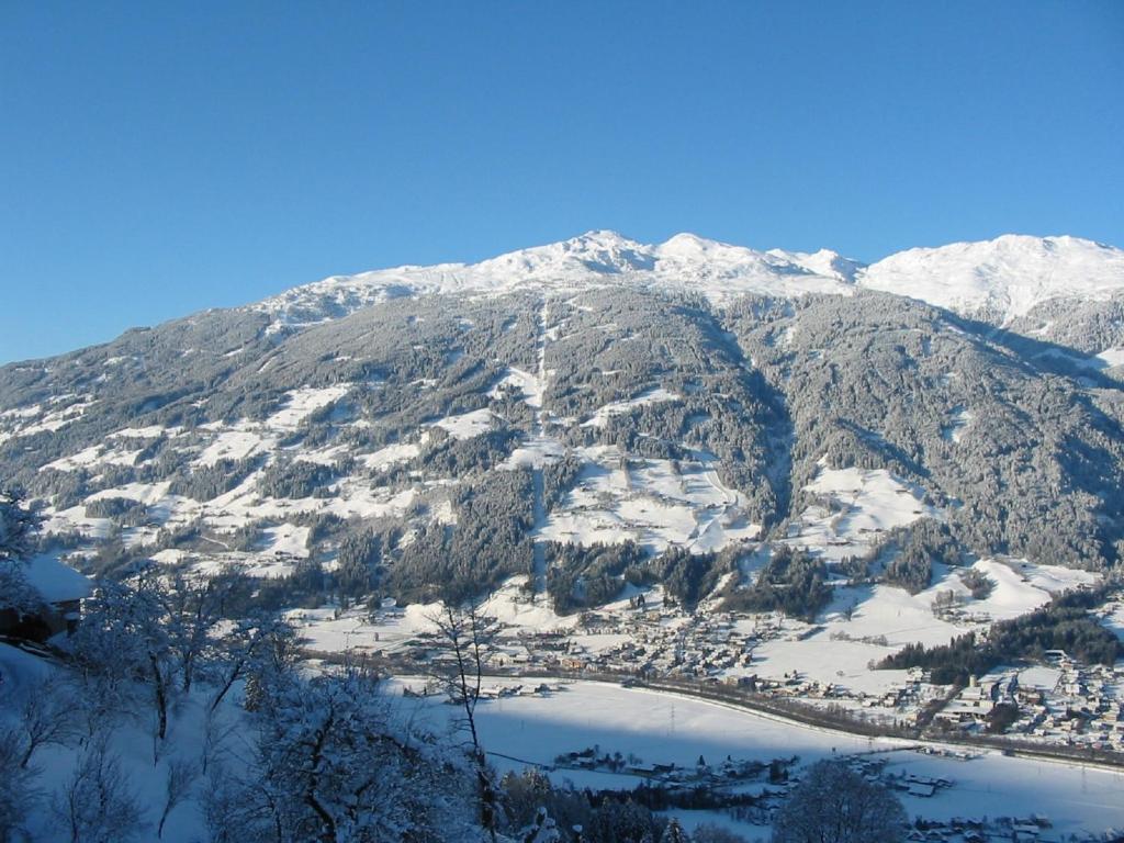 ein schneebedeckter Berg mit einem See in der Unterkunft Apartment Alpenblick in Stummerberg
