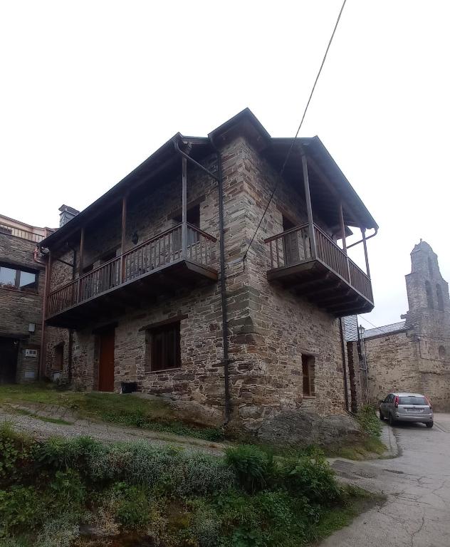 an old stone building with a balcony on it at Casa de Abril 2 in San Cristóbal de Valdueza