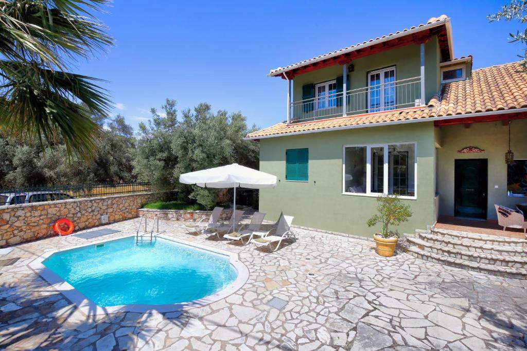 a villa with a swimming pool in front of a house at Elite Escape in Tsoukalades