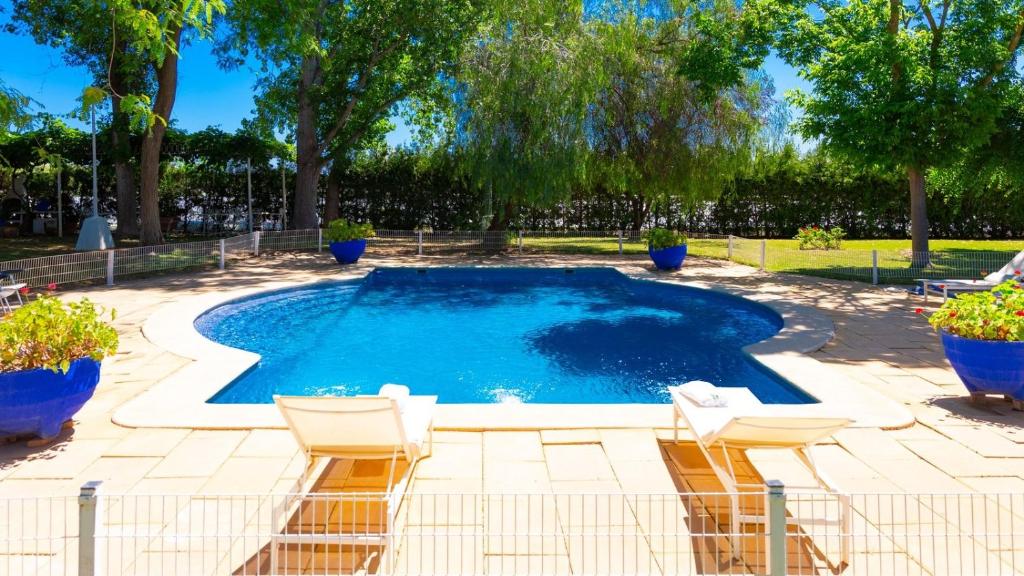 ein Swimmingpool mit zwei Stühlen in der Unterkunft Casa San Ignacio Cantillana by Ruralidays in Sevilla