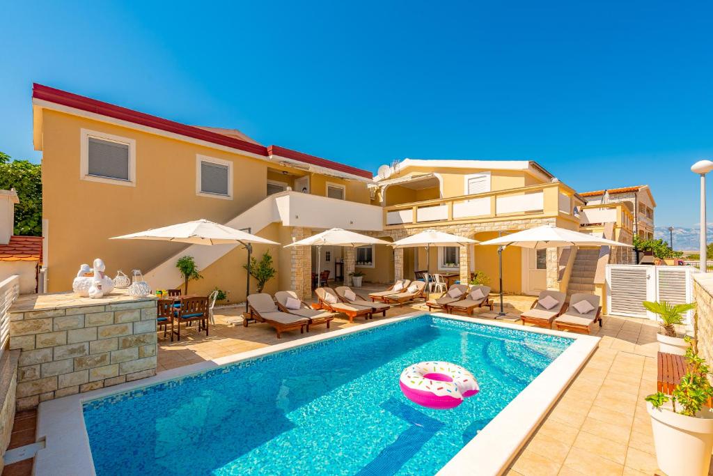 une piscine devant une maison dans l'établissement Villa Karmen - Poolhouse, à Vir