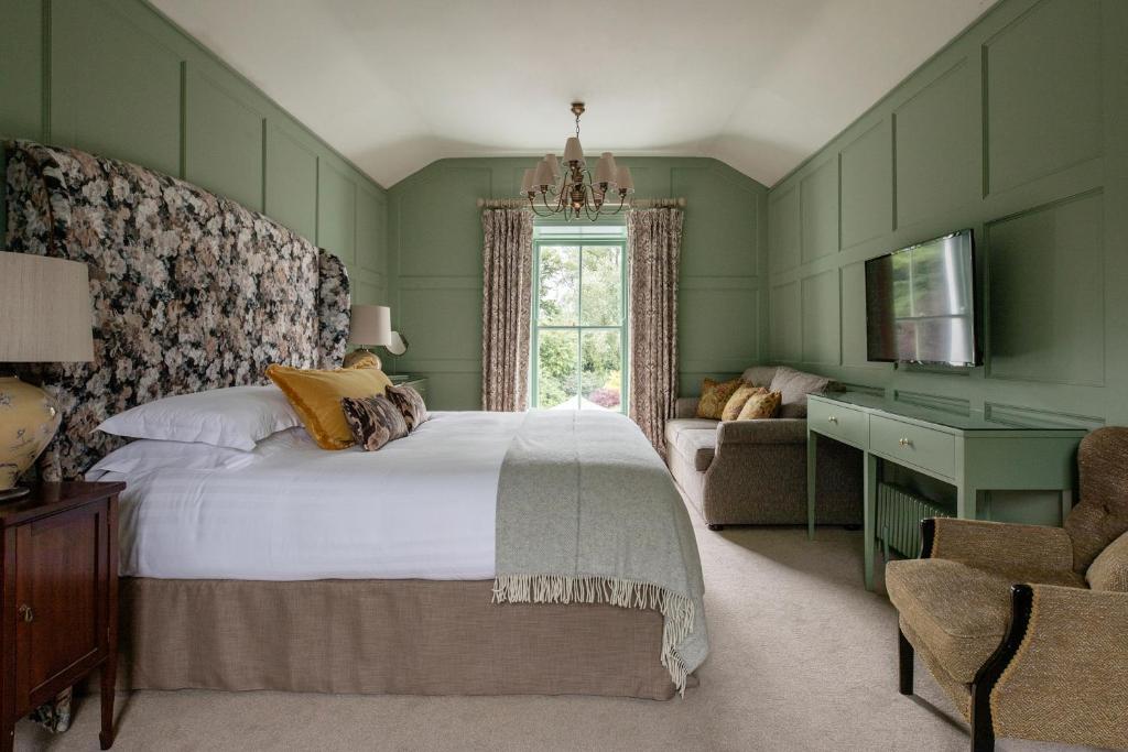 a bedroom with a bed and a chair and a window at The Station House Hotel in Kilmessan