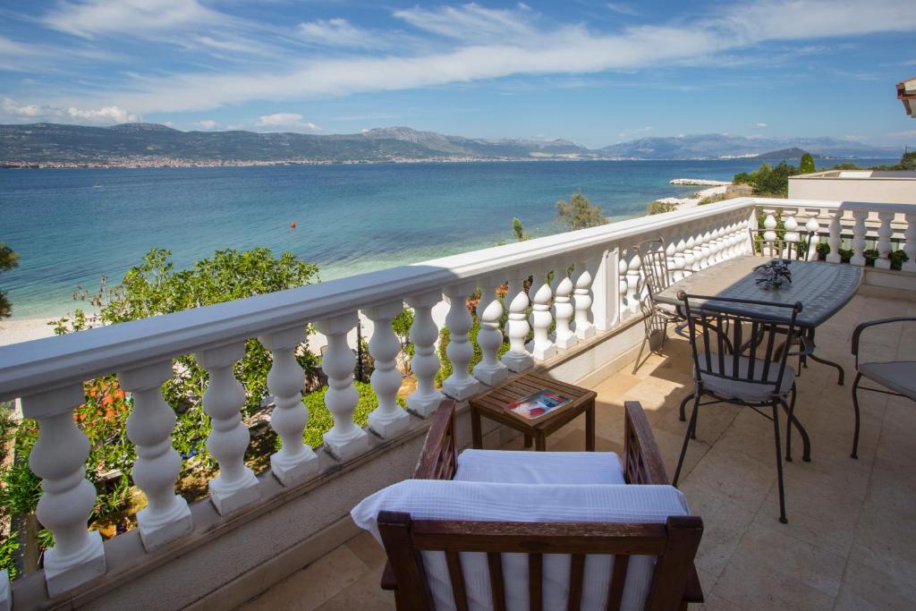 a balcony with tables and chairs and a view of the ocean at Situs Katarina in Trogir
