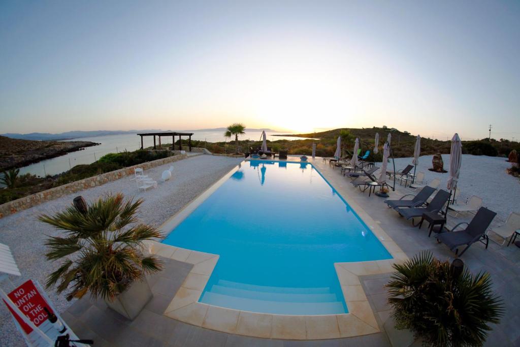 une grande piscine avec des chaises et des parasols dans l'établissement Tersanas Beach Lodges, à Tersanas