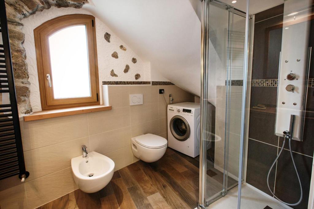 uma casa de banho com um lavatório e uma máquina de lavar roupa em La Marmote Albergo Diffuso di Paluzza Cleve em Paluzza