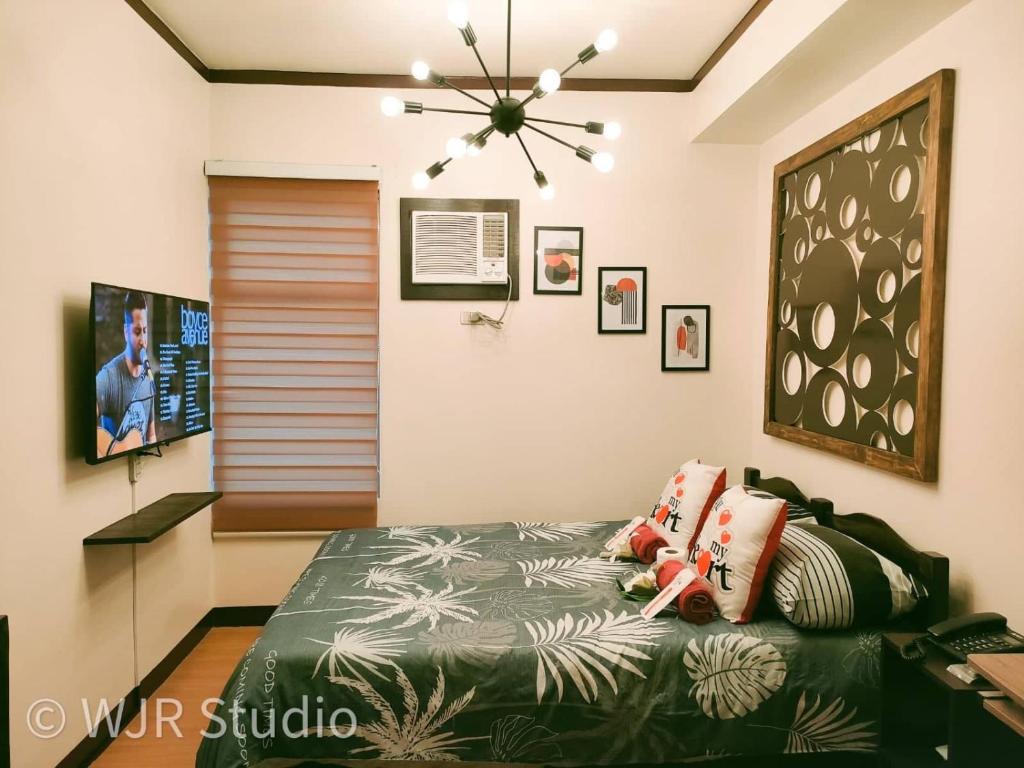 - une chambre avec un lit et un ventilateur de plafond dans l'établissement Centropolis Queen Bed Suite- Modern Posh Style, à Manille