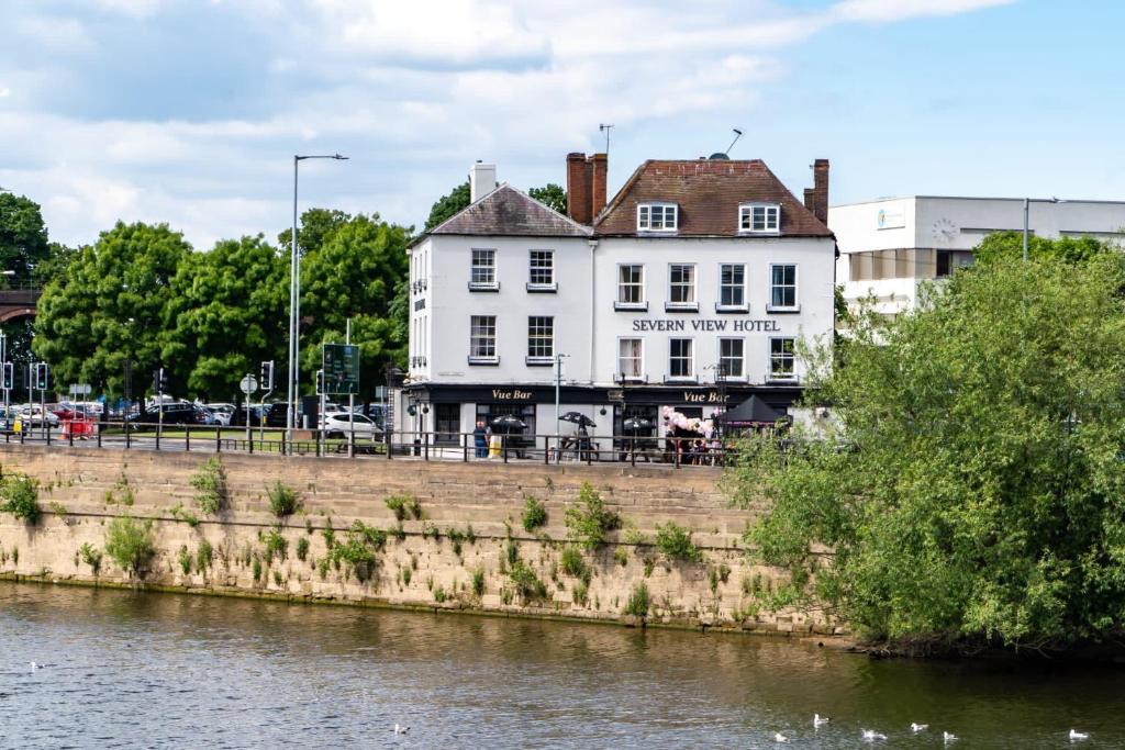 a white building sitting next to a river at Severn View Hotel in Worcester