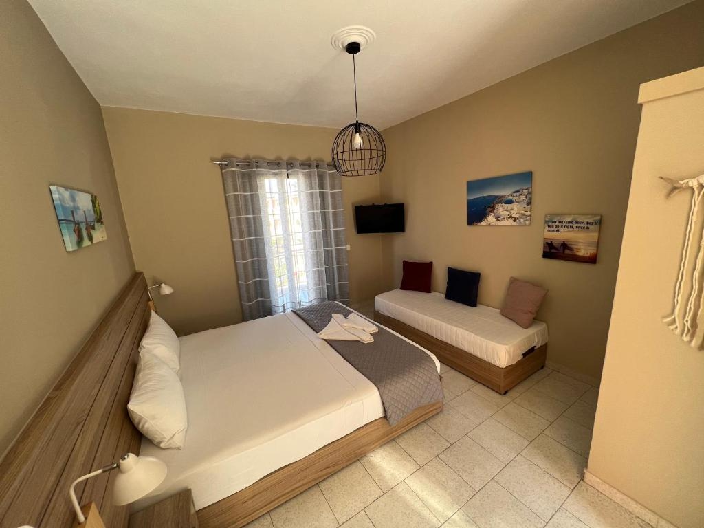 a small bedroom with two beds and a couch at Ilaeira rooms in Argassi