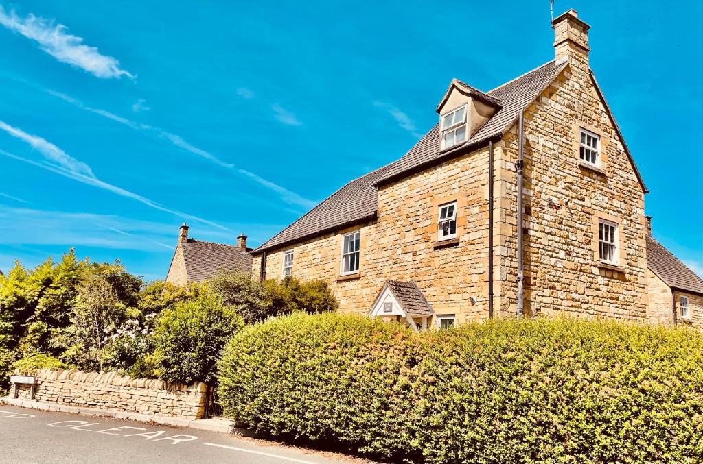 an old brick building with a tower on a street at Cotswold Chic Retreats "Cloud Nine" 5 Star Chipping Campden-Parking-Garden in Chipping Campden